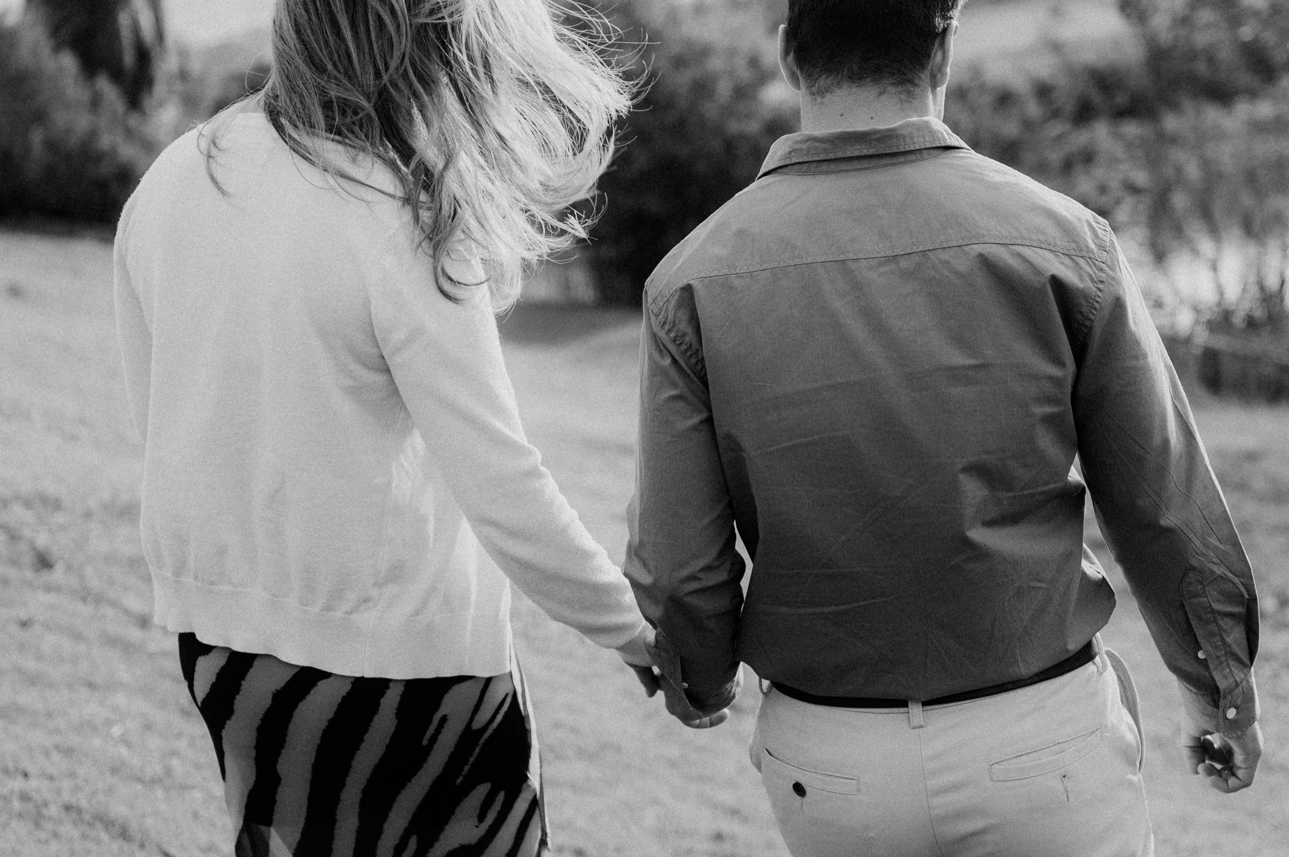 Cris and Vanessa walking hand in hand across a lawn